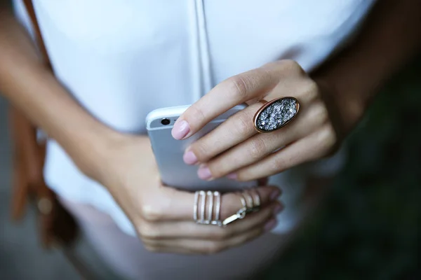Vrouwelijke handen met telefoon en stijlvolle ringen, close-up — Stockfoto
