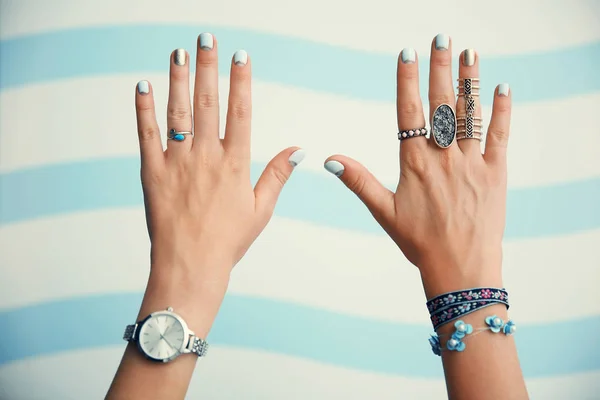 Vrouwelijke handen met sieraden op kleur achtergrond — Stockfoto