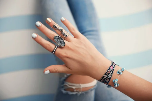 Vrouwelijke hand met sieraden op kleur achtergrond — Stockfoto