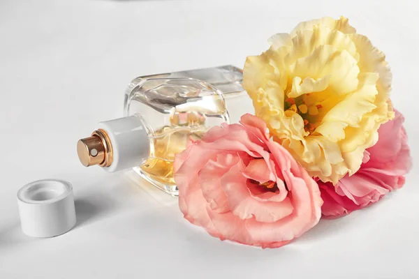 Parfüm şişesi ve beyaz arka plan üzerinde çiçek kompozisyon — Stok fotoğraf