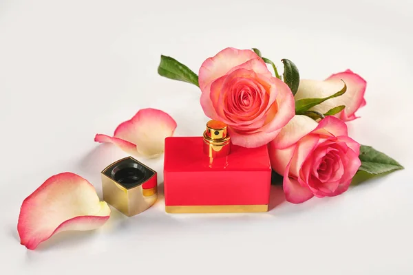 Composition du flacon de parfum et des roses sur fond blanc — Photo