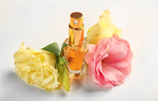 Composição da garrafa de perfume e flores sobre fundo branco — Fotografia de Stock