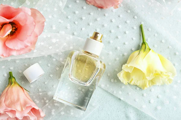 Parfümös üveg és a virágok, a világos háttér — Stock Fotó