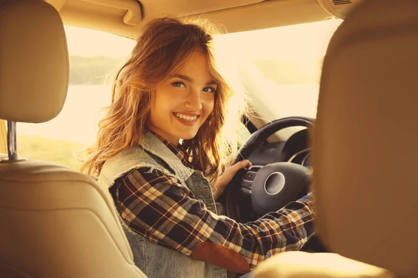 Молода жінка-водій в машині на березі річки — стокове фото