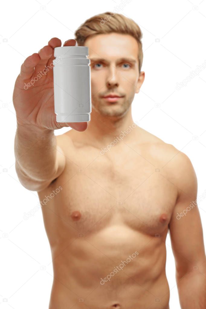 Muscular man holding drugs on white background