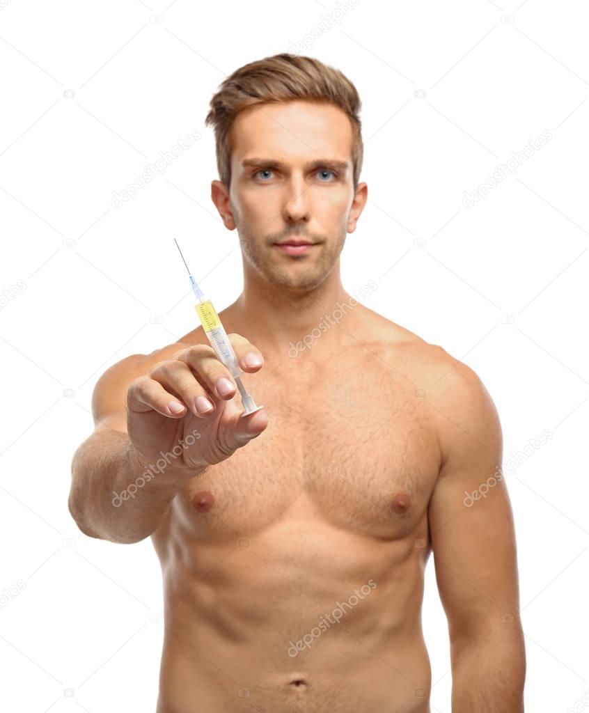 Muscular man holding syringe on white background