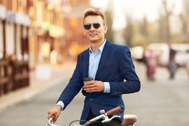 Kahve-to-go kavramı. Genç adam Bisiklet ve kahve Caddesi üzerinde