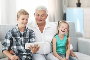 Dedesi ve torunları ile tablet kanepe üzerinde