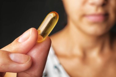 Balık yağı hapı kadın elinde