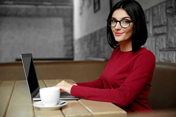Mooie jonge vrouw met behulp van laptop in cafe — Stockfoto
