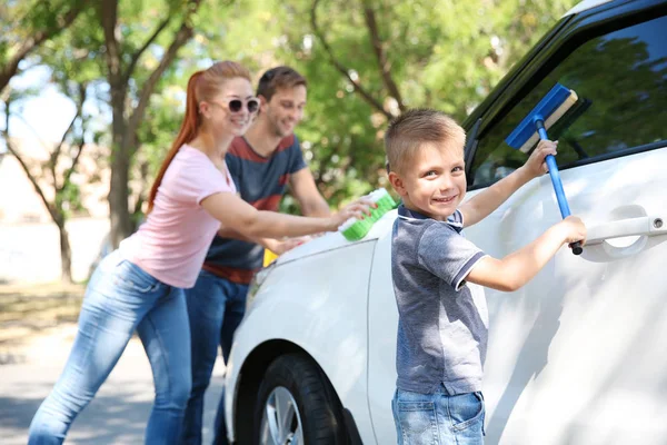 Gelukkige familie wassen auto op straat — Stockfoto