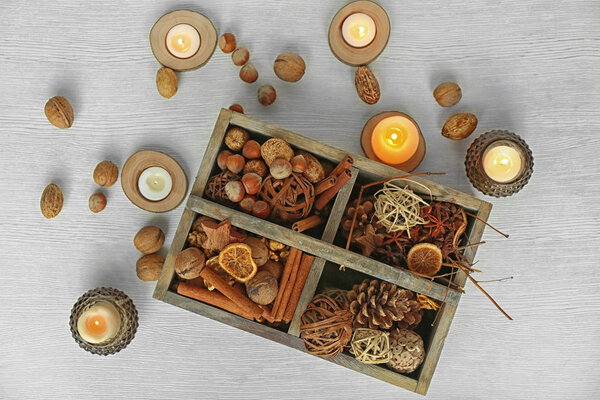 Ящик с рождественскими украшениями, орехами и специями на белом деревянном фоне
