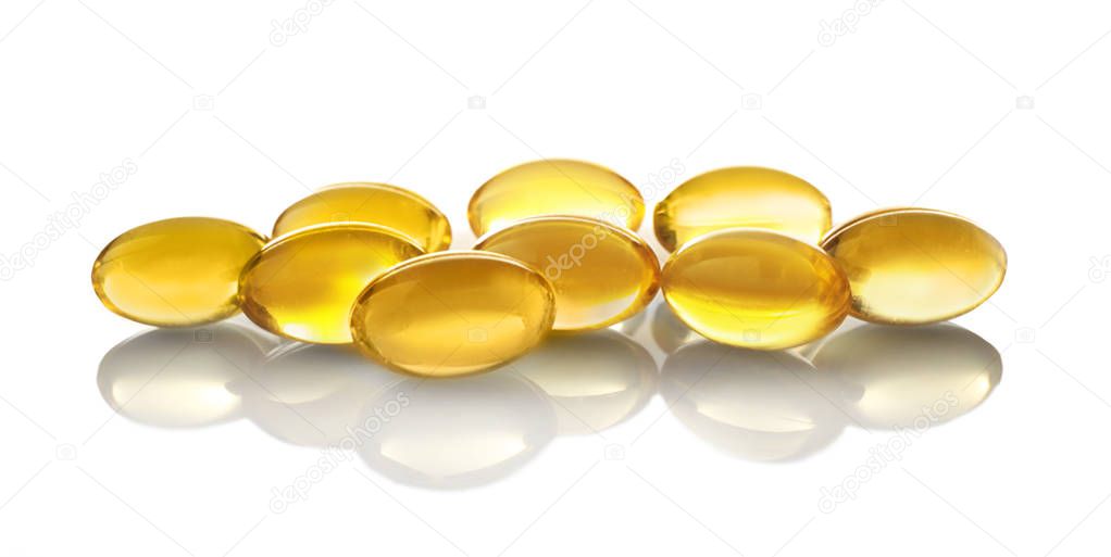 Capsules of fish oil on light background, close up view