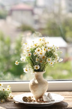 Pencere üzerinde papatya buketi