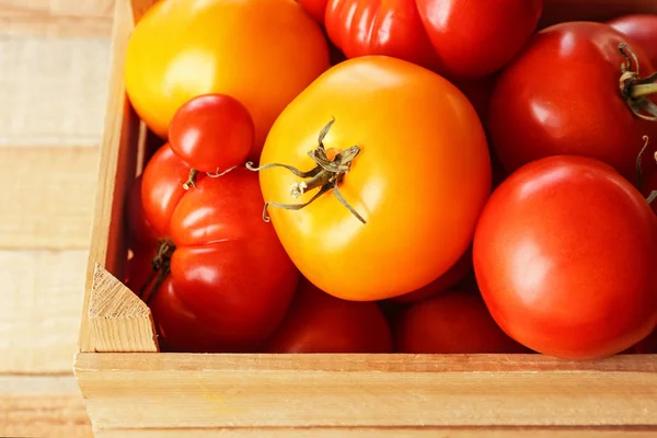 Verschillende tomaten in houten doos, close-up — Stockfoto