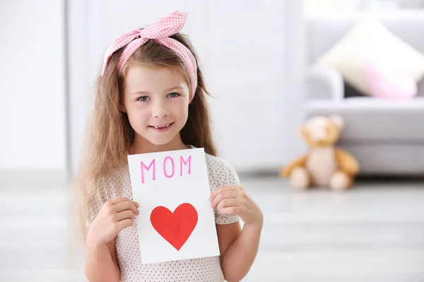 Menina bonito com cartão de saudação artesanal para a mãe em casa — Fotografia de Stock