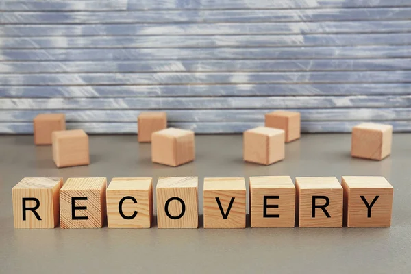 Word recovery written on wooden blocks on wall background — Stock Photo, Image