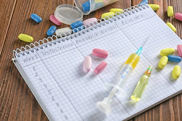 Caderno e drogas em fundo de madeira — Fotografia de Stock