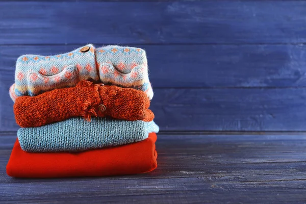 Stos ubrań ciepłe zimowe na niebieskim tle drewnianych — Zdjęcie stockowe