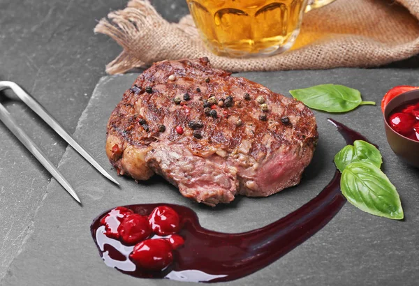 Lekkere sappige biefstuk met kruiden en saus op leisteen plaat — Stockfoto