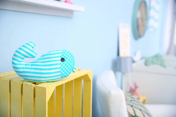 Brinquedo de baleia turquesa listrada na caixa de madeira amarela no quarto do bebê — Fotografia de Stock