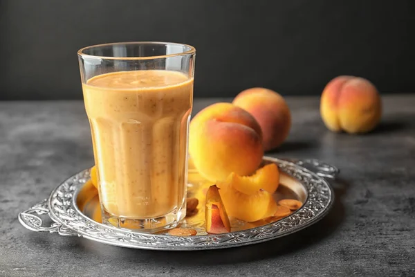 Vintage tray with smoothie and peach on grey table — Stock Photo, Image