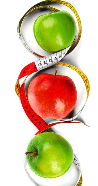 Concepto de dieta. Manzanas con cinta métrica sobre fondo blanco — Foto de Stock