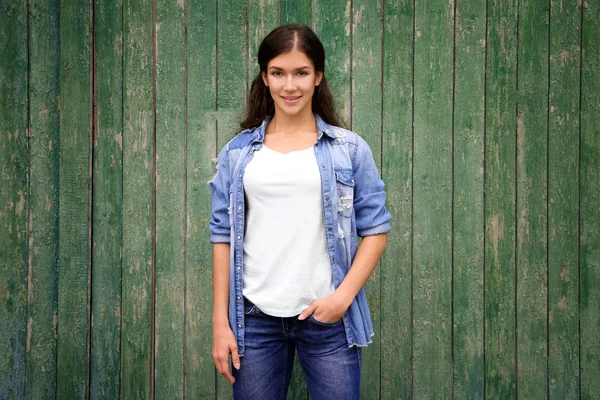 Beautiful girl on wooden wall background — Stock Photo, Image