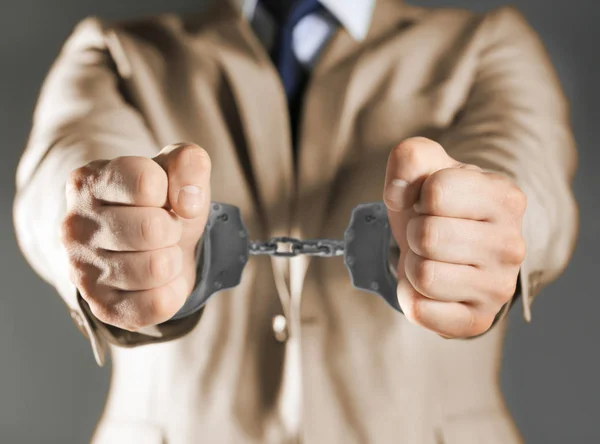 Чоловік в наручниках на сірому фоні — стокове фото