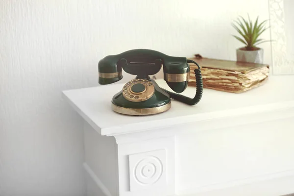 Vintage telephone on white mantelpiece — Stock Photo, Image
