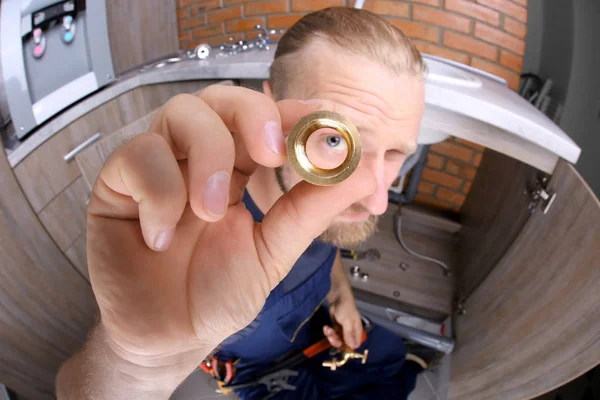 Funny plumber repairing sink in kitchen — Stock Photo, Image