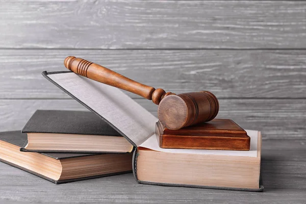 Judge's gavel and books on wooden wall background — Stock Photo, Image