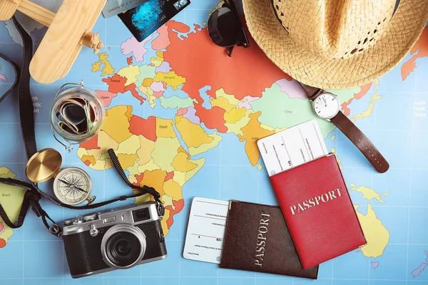Accessori per viaggiatori su sfondo mappa del mondo, vista dall'alto. Concetto di pianificazione viaggio — Foto Stock