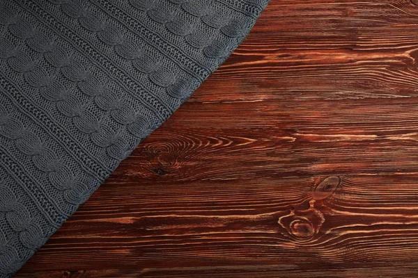 Серая трикотажная ткань на деревянном фоне — стоковое фото