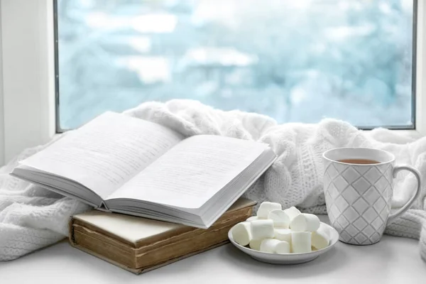 Hot drink with books and marshmallows on windowsill — Stock Photo, Image