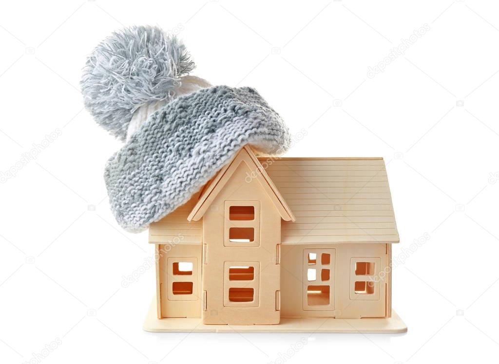 Plywood toy house with warm hat, isolated on white