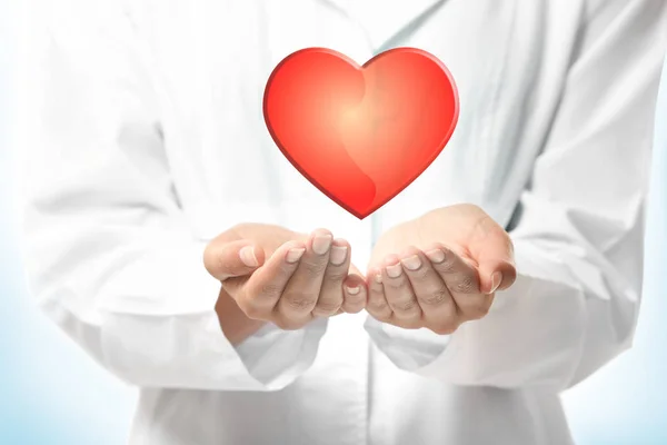 Kırmızı kalp kalp doktoru elleriyle — Stok fotoğraf