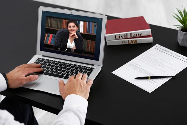 Man video conferencing with lawyer on laptop. Video call and online service concept.