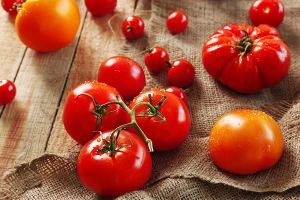 Composizione rustica di pomodori e sacco su fondo di legno — Foto Stock