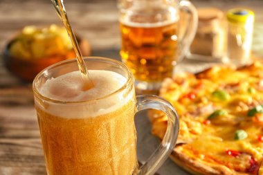 Bira cam ve arka plan üzerinde pizza içine dökme