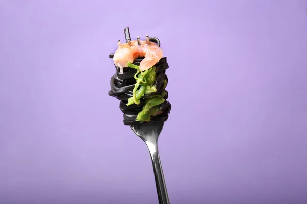 Tenedor con pasta negra y camarones sobre fondo de color —  Fotos de Stock