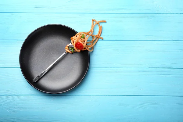 파스타와 토마토 검은 접시에 포크 — 스톡 사진