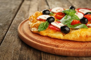 Mantar, domates, zeytin ve fesleğen ahşap arka plan üzerinde lezzetli pizza