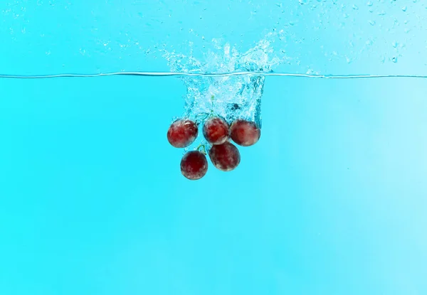 Raisins tombant dans l'eau — Photo