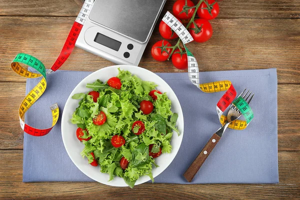 Свежий здоровый салат и весы — стоковое фото