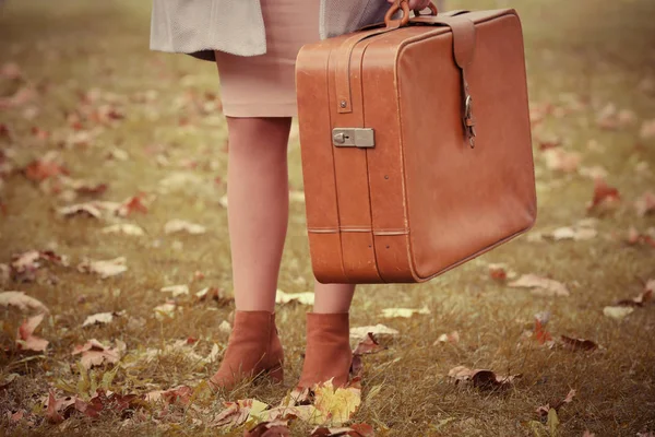 Mujer con maleta en un parque de otoño — Foto de Stock