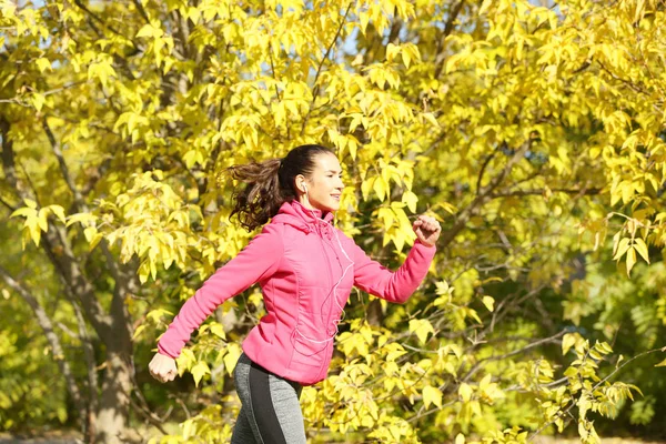 Sporty young woman in autumn park — Stock Photo, Image