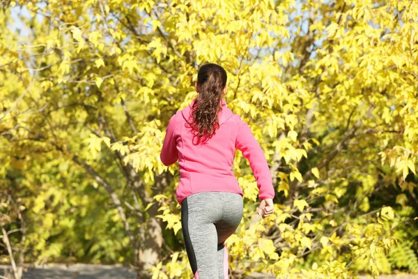 Giovane donna sportiva nel parco autunnale — Foto Stock