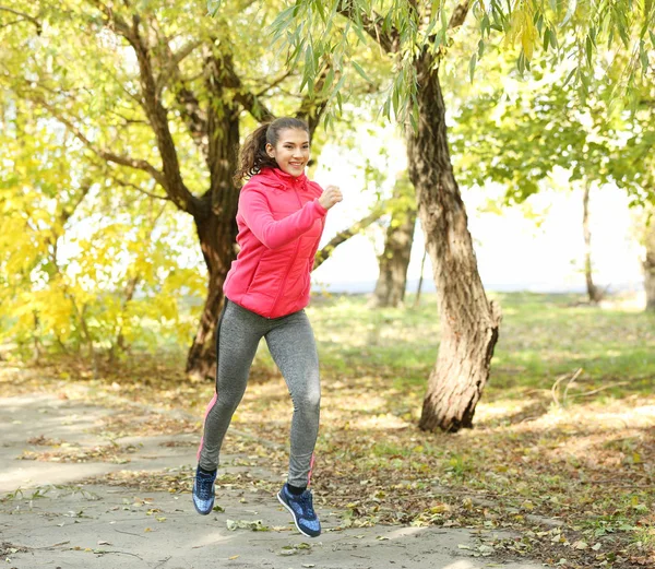 Спортивная молодая женщина в осеннем парке — стоковое фото