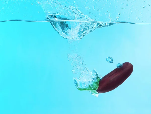 Eggplant falling into water Royalty Free Stock Images